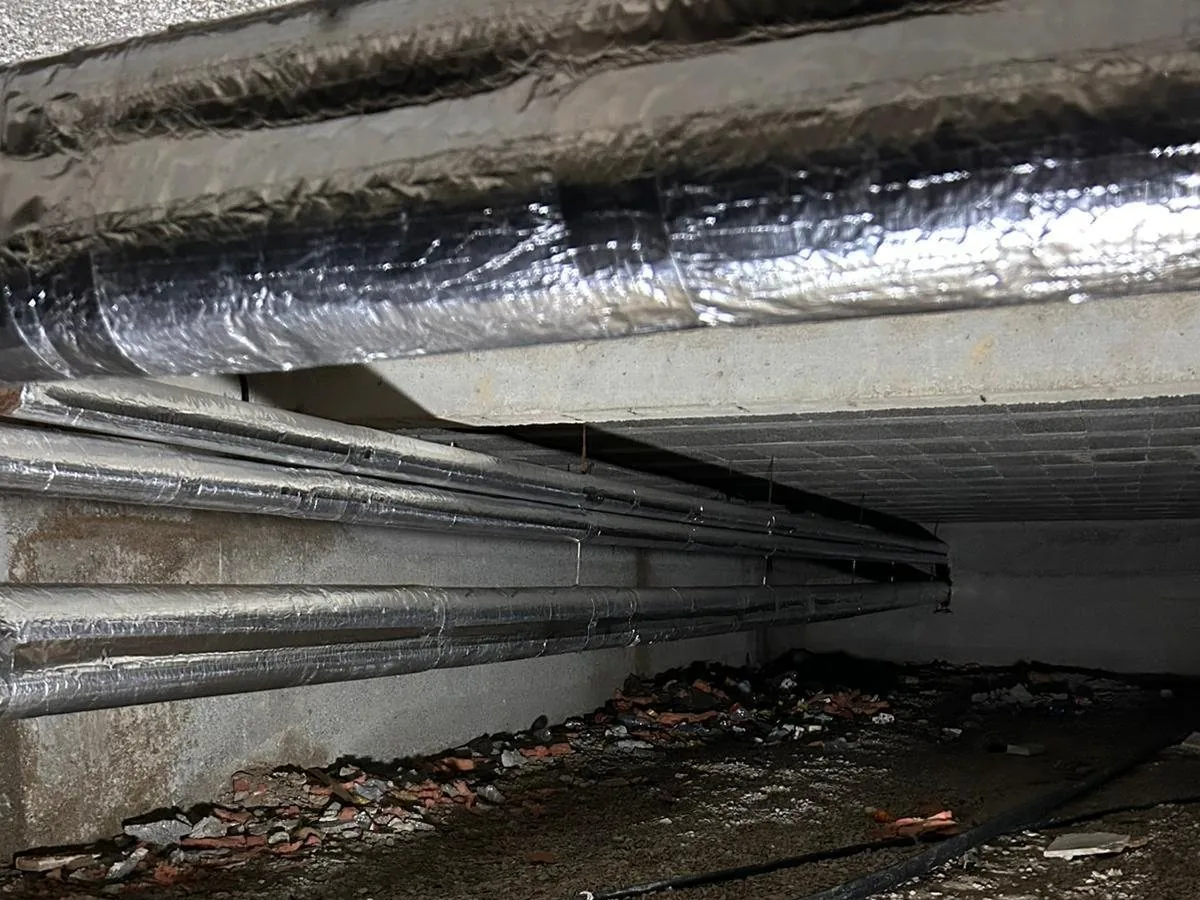 Insulated domestic hot water network in a crawl space with less than one metre of ceiling height